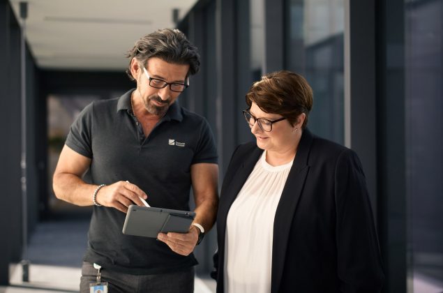 Ein amnn und eine Frau besprechen etwas zusammen auf einem Tablett