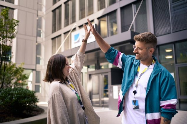 Ein junger Mann und eine jungen Frau geben sich highfive