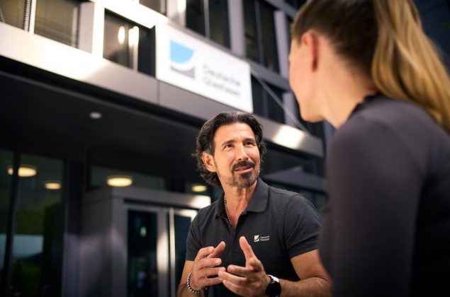 Ein dunkelhaariger Mann im Gespräch mit einer blonden Frau