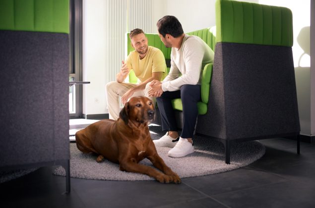 Zwei Männer und ein Hund in einem Arbeitsbereich